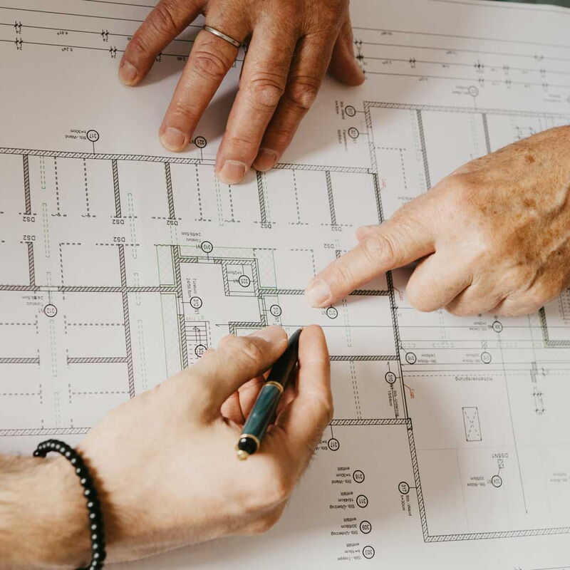 3 Hände auf einem Bauplan Zeigen und notieren.