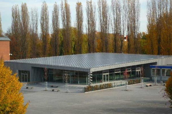 Foto des Projektes Neubau einer Mensa im Schulungszentrum. Im Hintergrund sing große Bäume zu sehen.