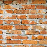 Grob verputzte Backsteinmauer.