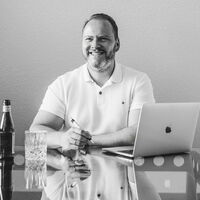 Der Geschäftsführer Ingo Maaß sitz an einem Laptop und einem Stift in der Hand.