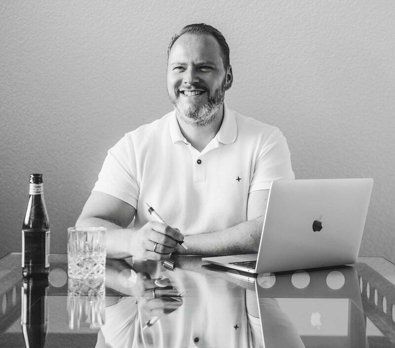 Der Geschäftsführer Ingo Maaß sitz an einem Laptop und einem Stift in der Hand.